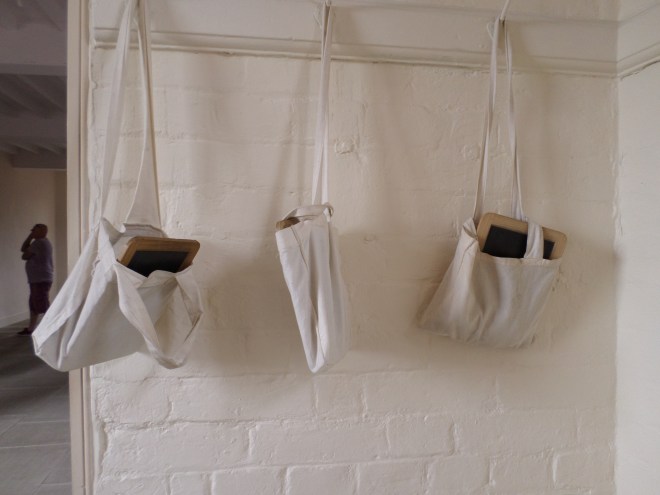 Childrens' slates hanging in the classroom of the workhouse.
